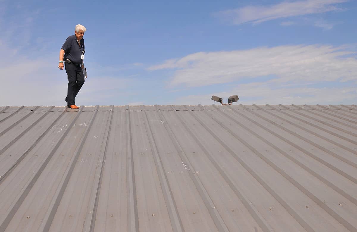 Roofer does hail damage inspection on metal roof